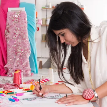 A woman fashion designer making dress sketches at a ladies boutique